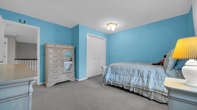 carpeted bedroom with baseboards and a closet