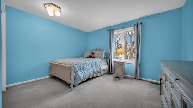 bedroom featuring light carpet and baseboards