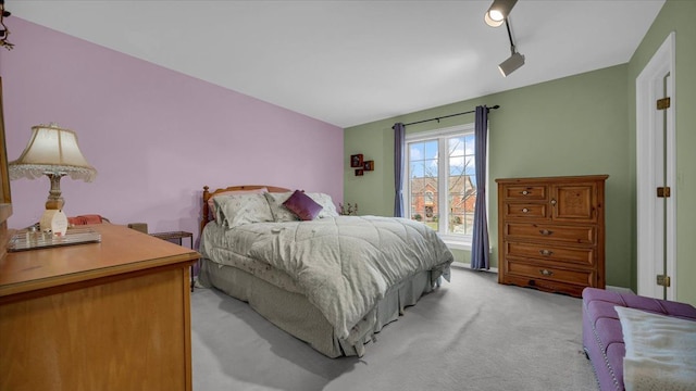 bedroom with light carpet and track lighting