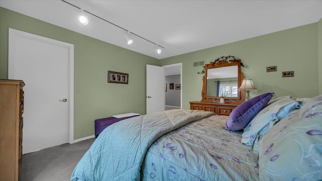 carpeted bedroom with rail lighting and visible vents
