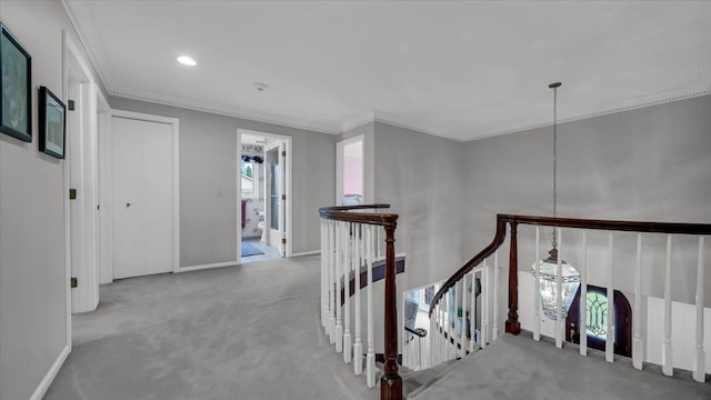 corridor featuring carpet, ornamental molding, and an upstairs landing