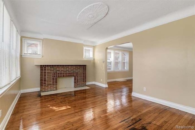 6127 Grayton St, Detroit, MI 48224 - unfurnished living room featuring arched walkways, a tile fireplace, baseboards, and wood finished floors