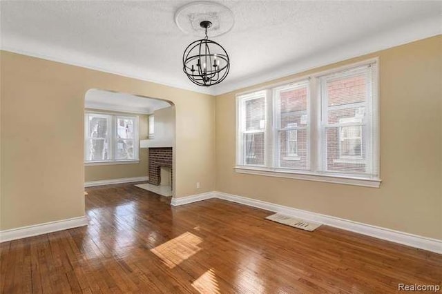 6127 Grayton St, Detroit, MI 48224 - unfurnished living room with an inviting chandelier, baseboards, visible vents, and hardwood / wood-style flooring
