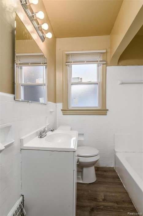 6127 Grayton St, Detroit, MI 48224 - bathroom with toilet, a bathtub, vanity, and wood finished floors