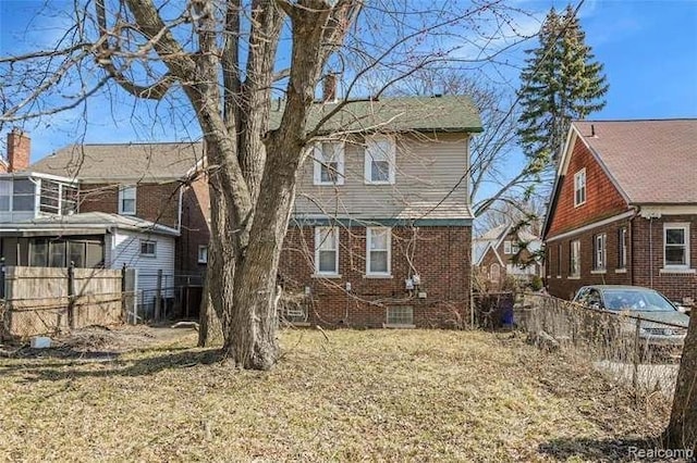 6127 Grayton St, Detroit, MI 48224 - rear view of property featuring a lawn, fence, and brick siding