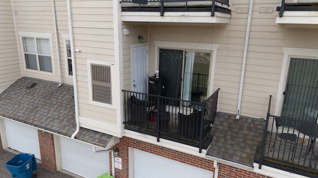 207 Legato Dr, Walled Lake, MI 48390 - view of exterior entry featuring a balcony, brick siding, and an attached garage