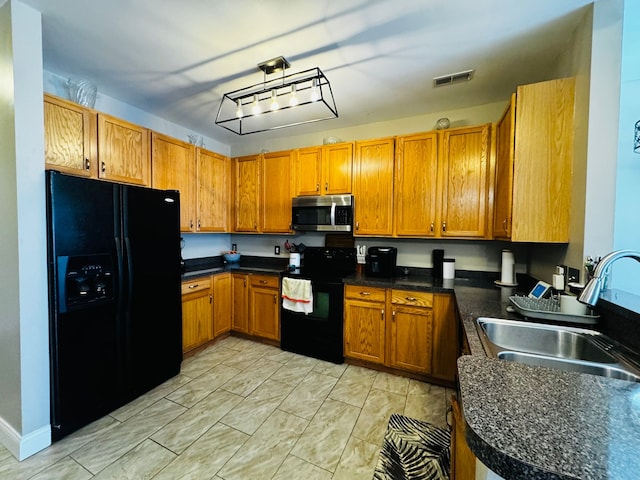 207 Legato Dr, Walled Lake, MI 48390 - kitchen with black appliances, a sink, brown cabinets, and dark countertops
