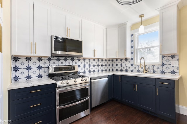 kitchen with light countertops, appliances with stainless steel finishes, a sink, and white cabinetry