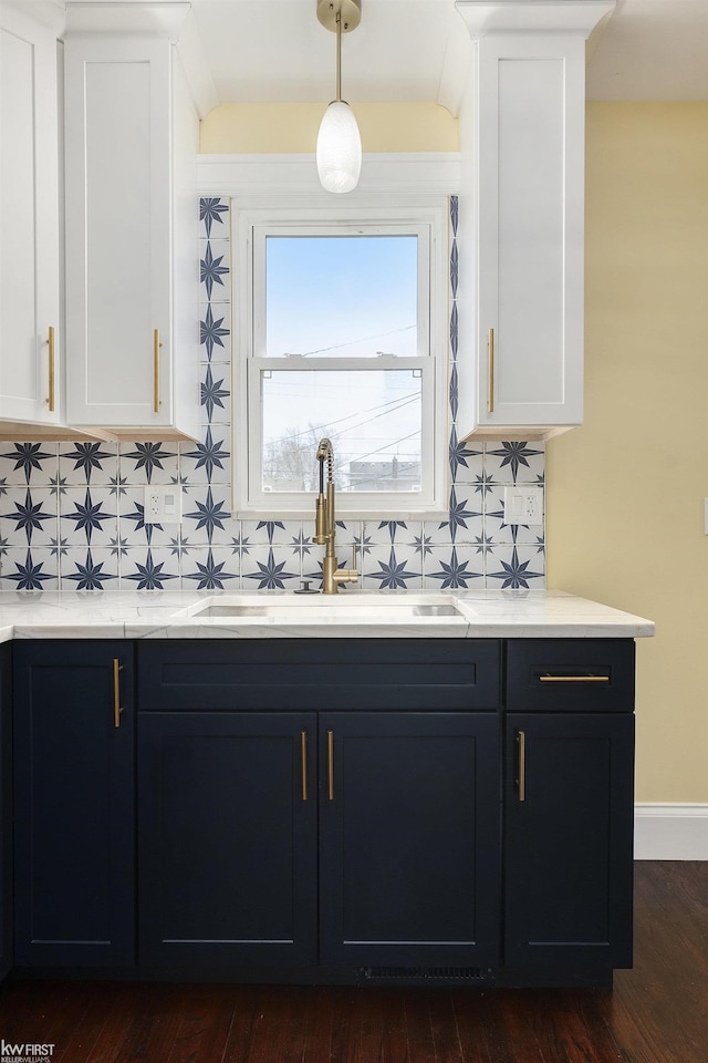 interior space featuring dark wood-style flooring, a sink, backsplash, and white cabinets
