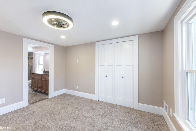 unfurnished bedroom featuring a sink, a closet, recessed lighting, and carpet flooring