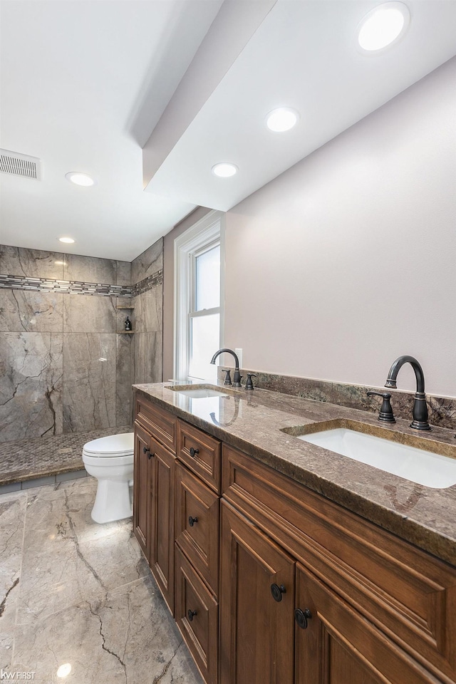bathroom with toilet, a stall shower, marble finish floor, and a sink