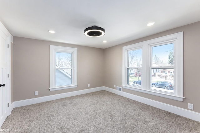 carpeted empty room featuring recessed lighting, visible vents, and baseboards