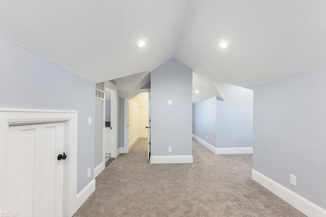 additional living space with visible vents, baseboards, recessed lighting, light carpet, and lofted ceiling