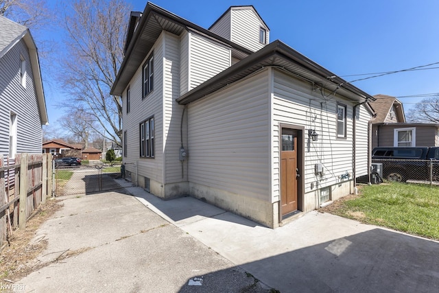 view of property exterior featuring a patio area, fence, and a gate