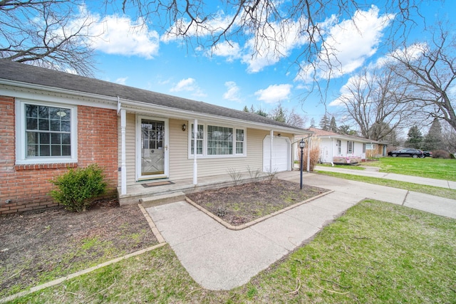 ranch-style house with concrete driveway, a garage, a front lawn, and brick siding