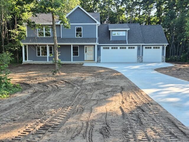 2035 Dakota Trl, Hastings, MI 49058 - traditional-style home with an attached garage, concrete driveway, and view of scattered trees