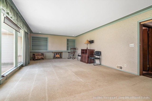 1220 W Green St, Hastings, MI 49058 - carpeted living room with a glass covered fireplace, visible vents, and built in features