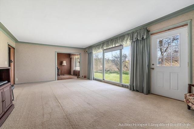 1220 W Green St, Hastings, MI 49058 - unfurnished living room with crown molding, a healthy amount of sunlight, visible vents, and carpet floors
