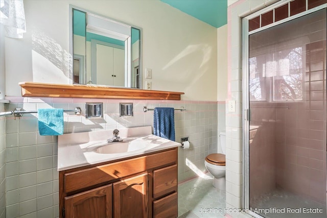 1220 W Green St, Hastings, MI 49058 - full bathroom featuring vanity, toilet, wainscoting, tile walls, and a stall shower