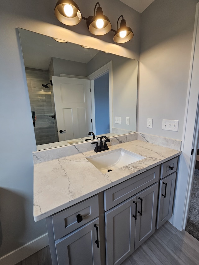 bathroom featuring a tile shower and vanity