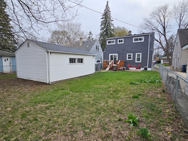 rear view of house featuring a fenced backyard, an outdoor structure, a chimney, and a yard