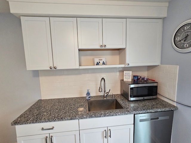 kitchen with backsplash, open shelves, a sink, stainless steel appliances, and white cabinetry