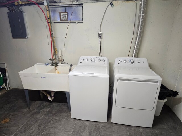 laundry area featuring laundry area, a sink, washer and clothes dryer, and electric panel