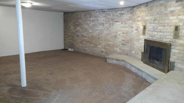 finished below grade area featuring brick wall, a brick fireplace, and carpet floors