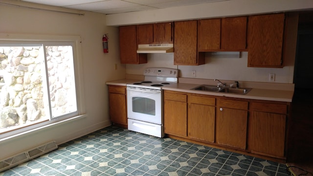 kitchen featuring white electric range oven, light countertops, under cabinet range hood, and a sink