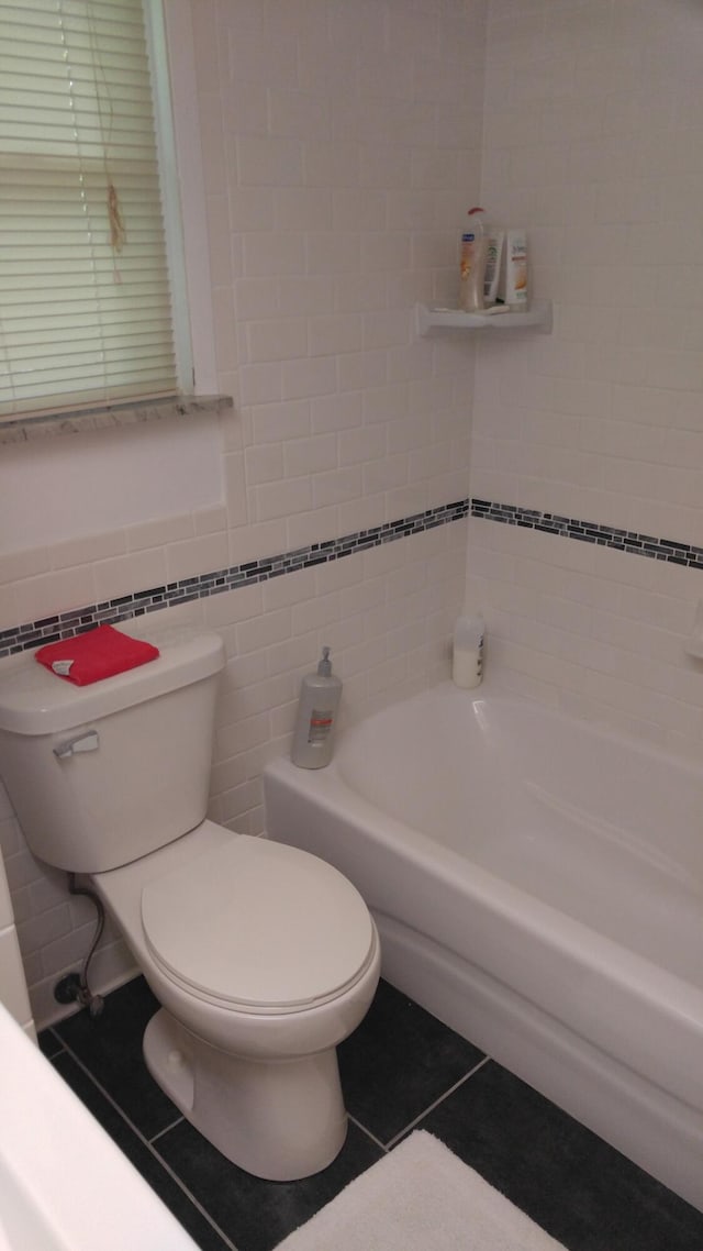 full bathroom with toilet, tile walls, and tile patterned floors