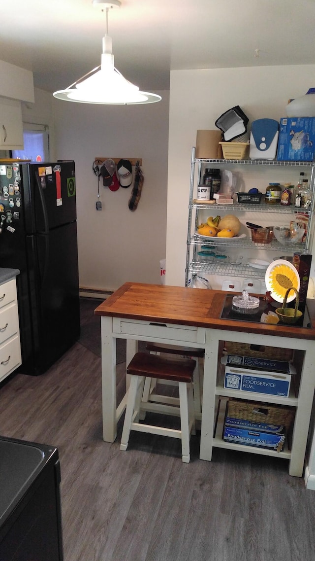 kitchen featuring white cabinetry, a baseboard radiator, freestanding refrigerator, and dark wood finished floors