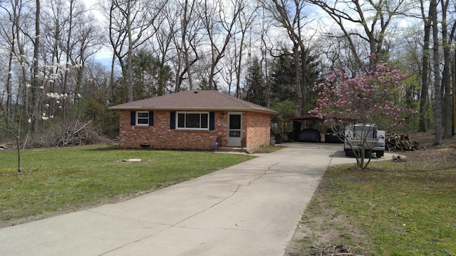 view of front of home featuring driveway, a front yard, and brick siding