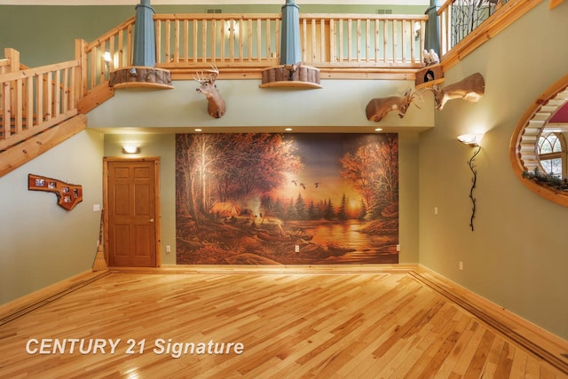 4285 N Iva Rd, Hemlock, MI 48626 - unfurnished living room with hardwood / wood-style flooring, a towering ceiling, and baseboards