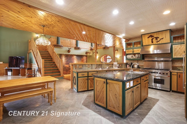 4285 N Iva Rd, Hemlock, MI 48626 - kitchen with stainless steel stove, a sink, exhaust hood, an island with sink, and dark stone counters