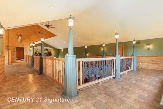 4285 N Iva Rd, Hemlock, MI 48626 - additional living space featuring wooden walls, ceiling fan, stone tile floors, decorative columns, and lofted ceiling