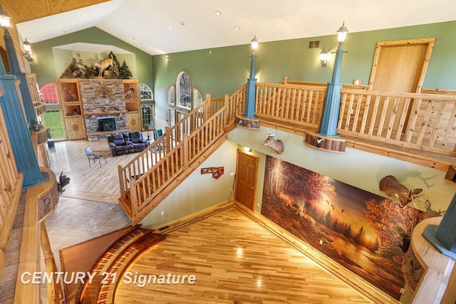 4285 N Iva Rd, Hemlock, MI 48626 - staircase with wood finished floors, a stone fireplace, and high vaulted ceiling