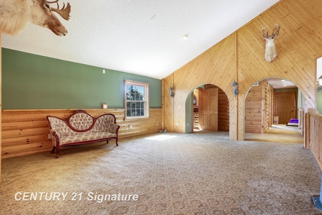 4285 N Iva Rd, Hemlock, MI 48626 - living area with arched walkways, wood walls, carpet flooring, high vaulted ceiling, and a wainscoted wall