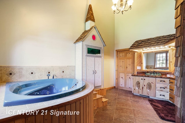 4285 N Iva Rd, Hemlock, MI 48626 - full bath featuring a high ceiling, a chandelier, vanity, a tub with jets, and tile patterned flooring
