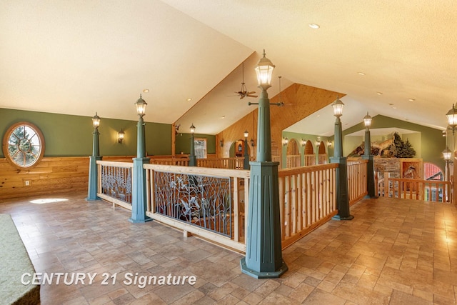 4285 N Iva Rd, Hemlock, MI 48626 - additional living space with wood walls, vaulted ceiling, stone tile floors, a ceiling fan, and a wainscoted wall