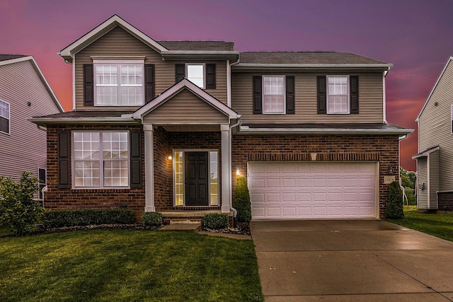 traditional-style home with a garage, concrete driveway, a front lawn, and brick siding