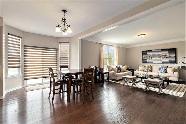 dining area with dark wood-style flooring, an inviting chandelier, and ornamental molding