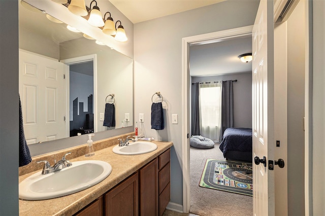 full bath with a sink, double vanity, and connected bathroom