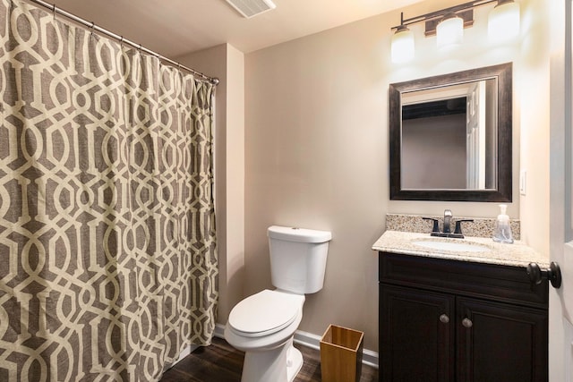 bathroom featuring visible vents, vanity, wood finished floors, toilet, and baseboards