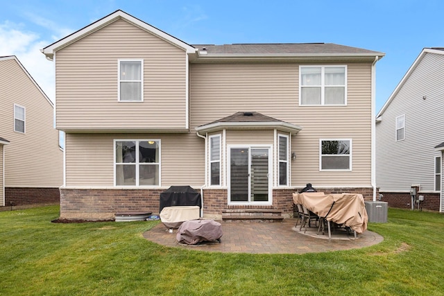 back of property featuring entry steps, a patio, a yard, and brick siding