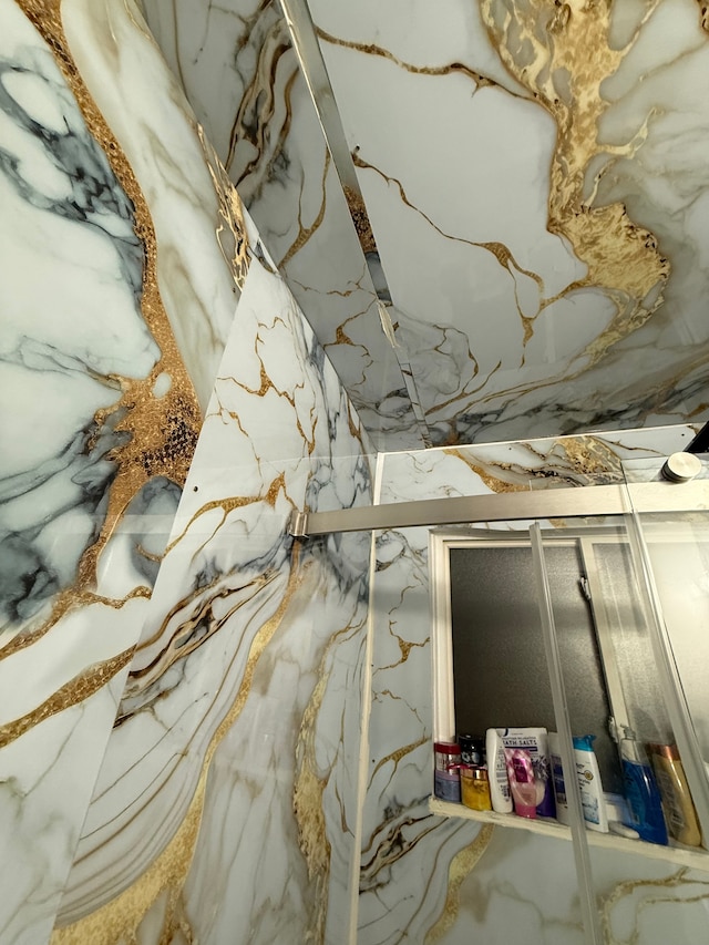 room details featuring a marble finish shower