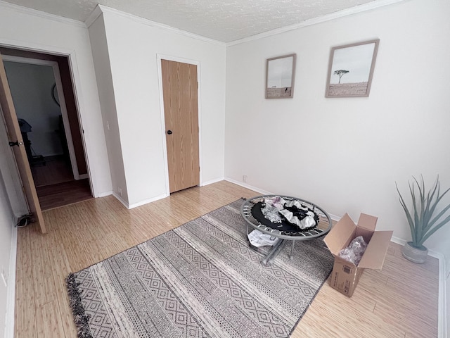 bedroom featuring crown molding, baseboards, and light wood-style floors