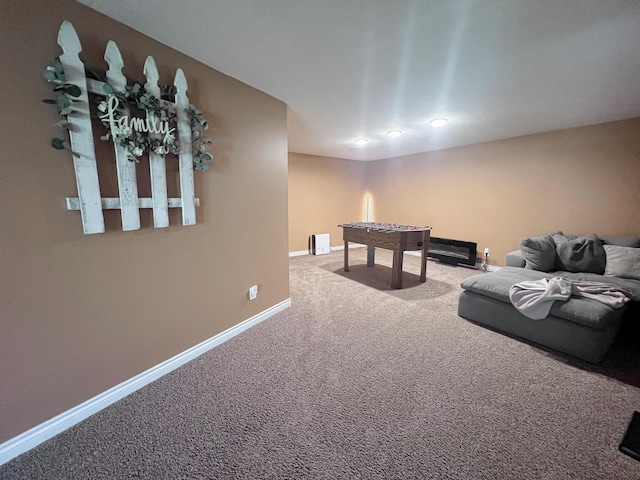 recreation room with baseboards and carpet
