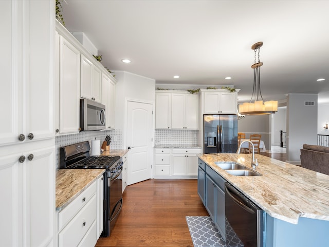 kitchen featuring white cabinets, backsplash, visible vents, a sink, and appliances with stainless steel finishes