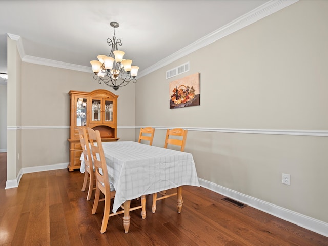 dining room featuring wood finished floors, visible vents, an inviting chandelier, and crown molding