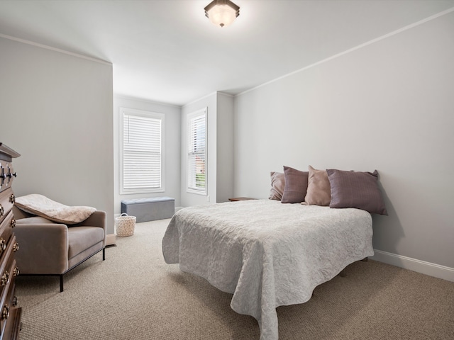 bedroom featuring baseboards, crown molding, and carpet